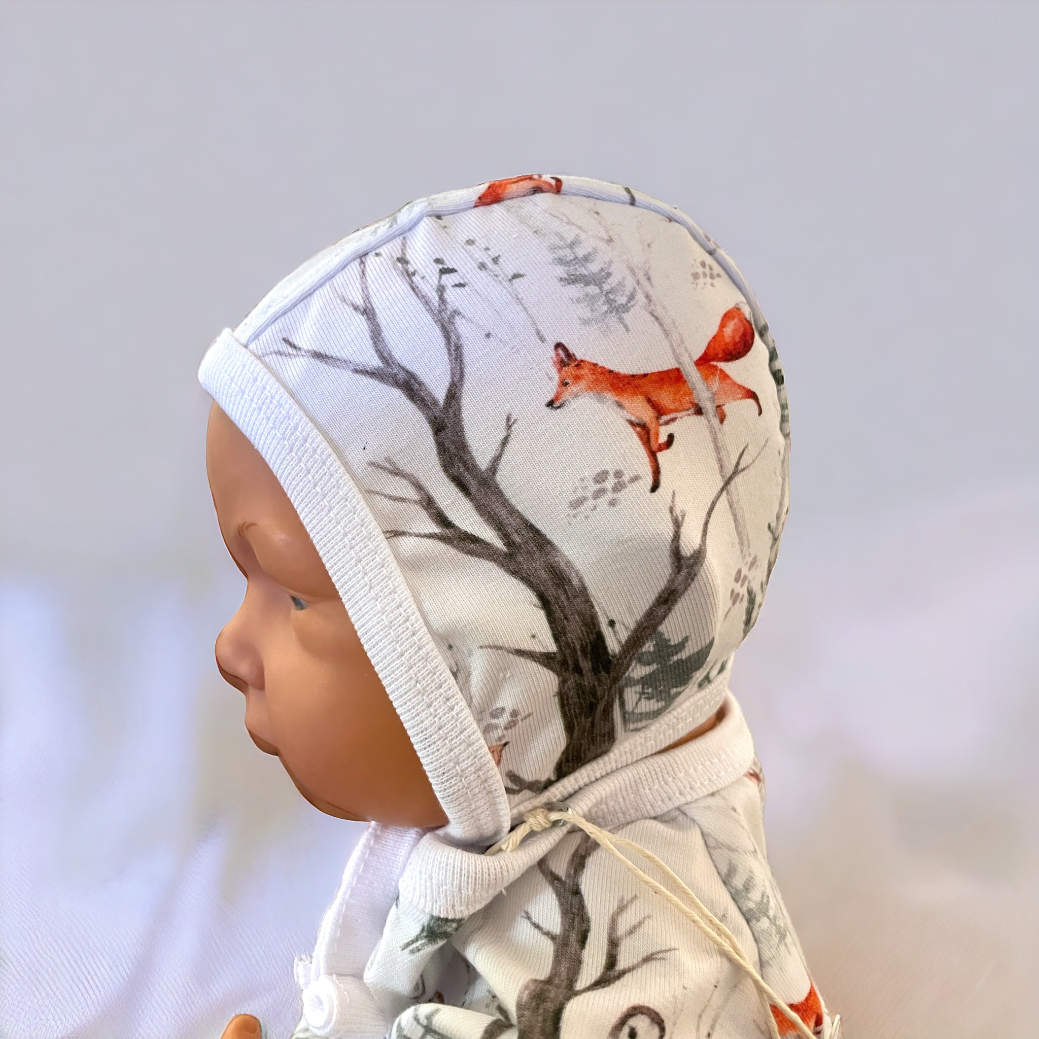 Hjälmmössa för baby i skogsglänta-motiv, knyt under hakan