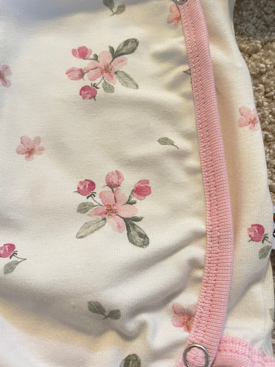 Omlottbody för baby i äppelblom, vitt kantband och tryckknappar i grenen