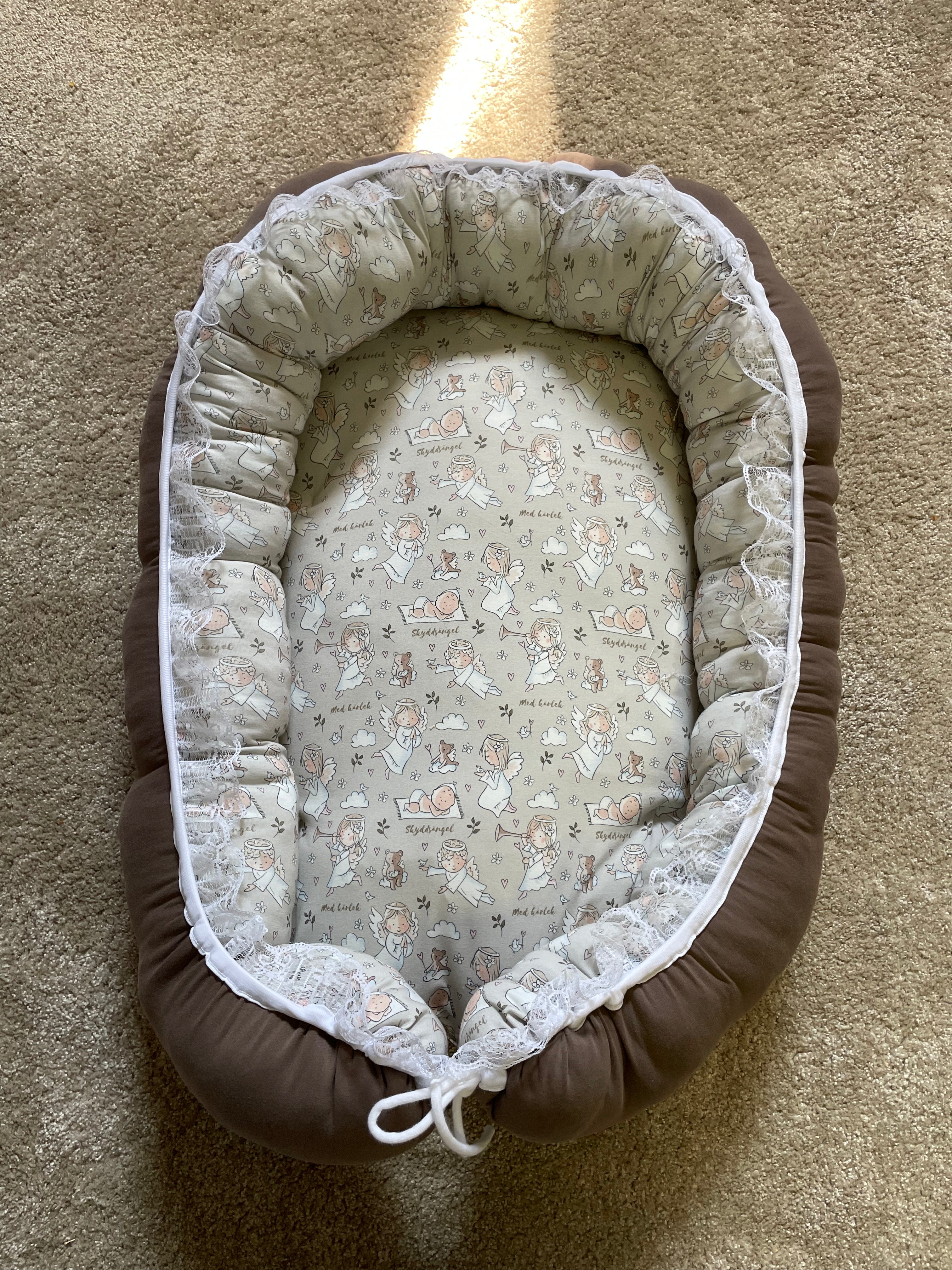 Närbild på babynest för baby, mjuk stödjande kant i bomullsjersey.