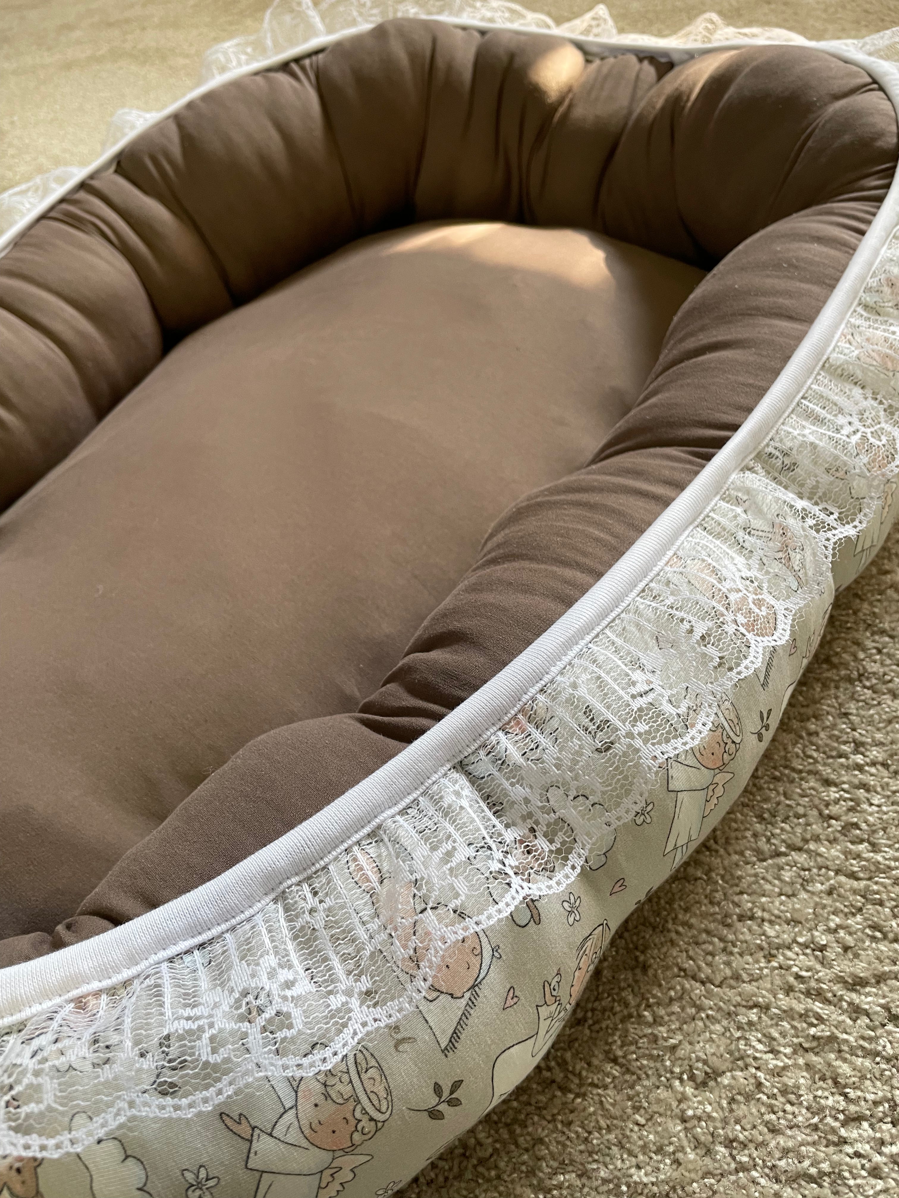 Vändbart babynest för baby med stödjande kanter i mjuk bomullsjersey.