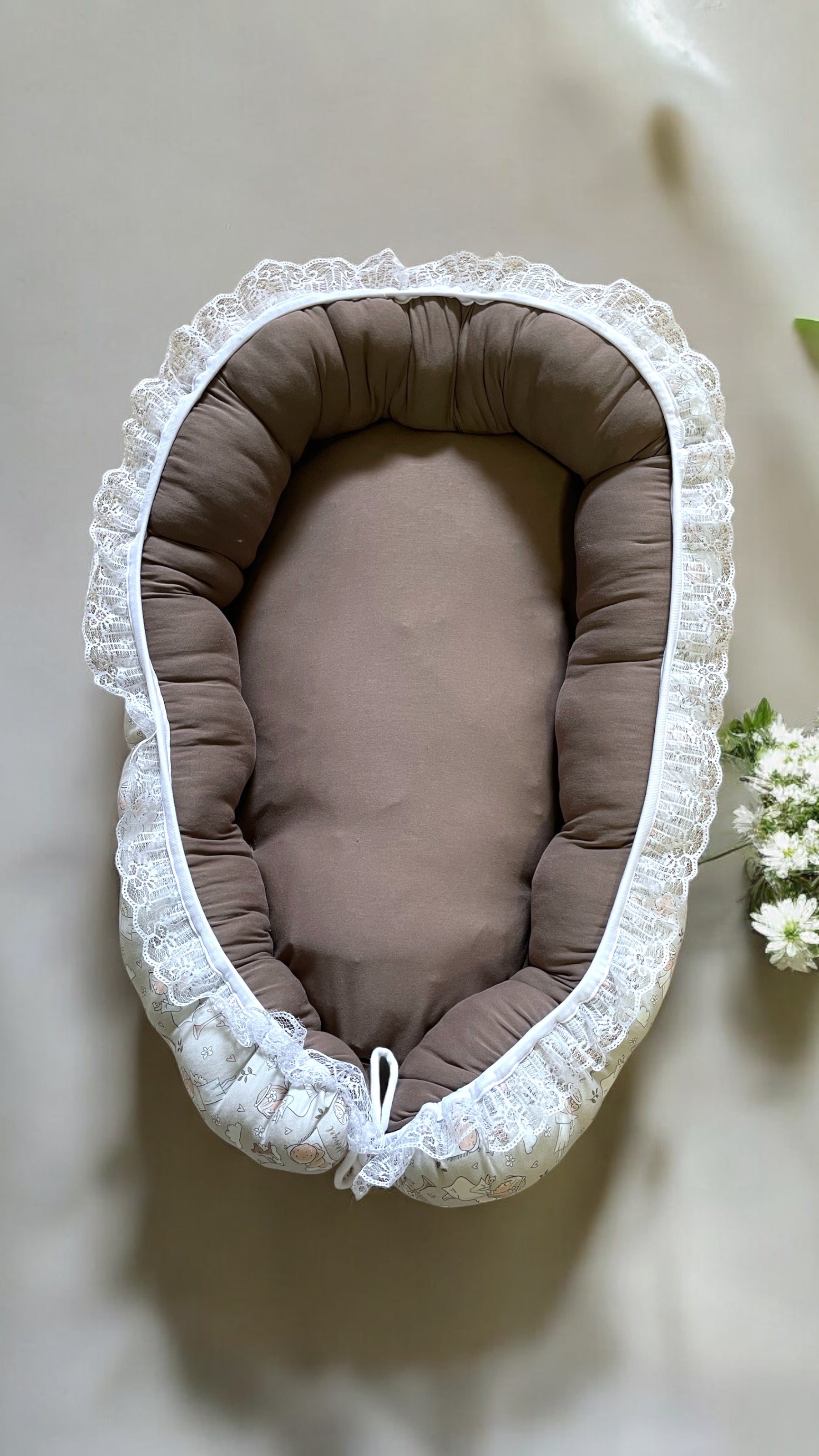 Babynest för baby i mönstret Skyddsängel, vändbart med mjuka stödjande sidor.