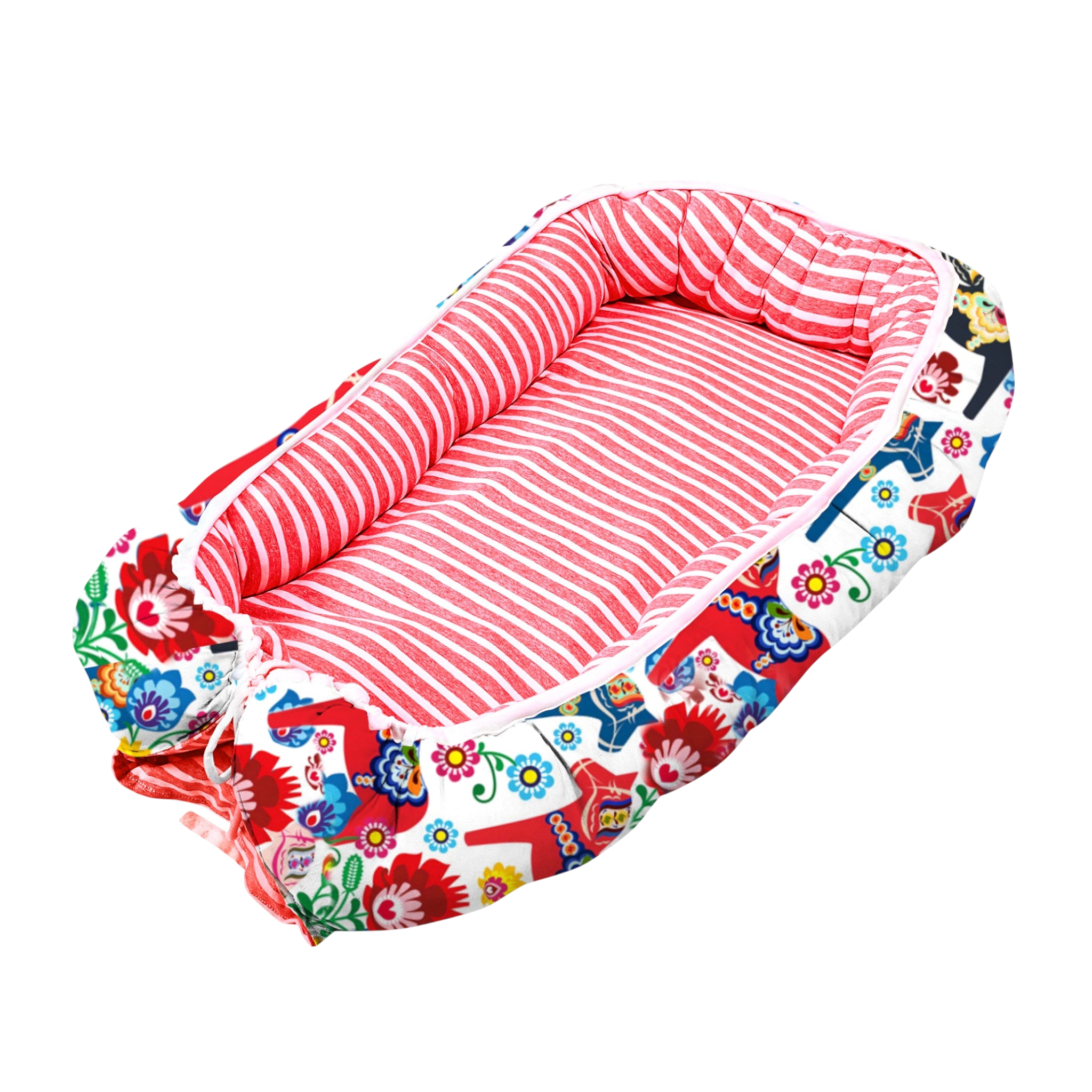 Babynest för baby i Dalahäst-mönster, vändbart med mjuka stödjande sidor.